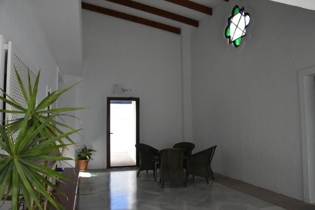 a room with a table and chairs and a potted plant at Hostal Doña Lola Marina in Zahara de los Atunes