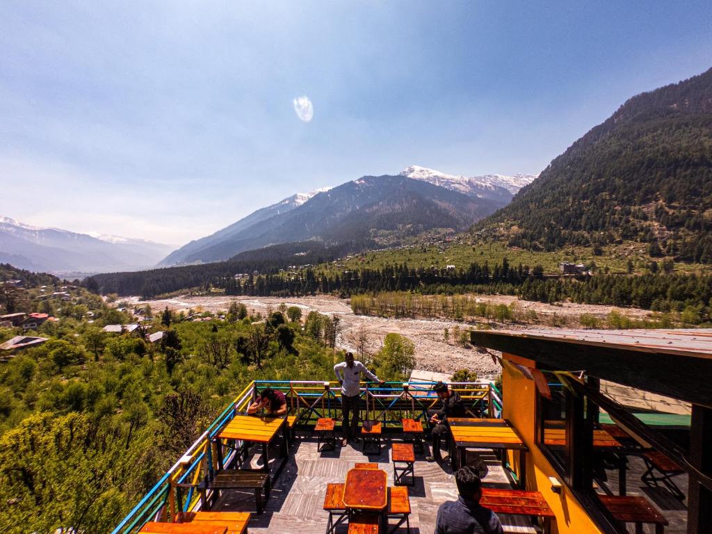 un gruppo di persone che si trovano su un balcone che guarda una valle di La Vaca India Manali a Manāli