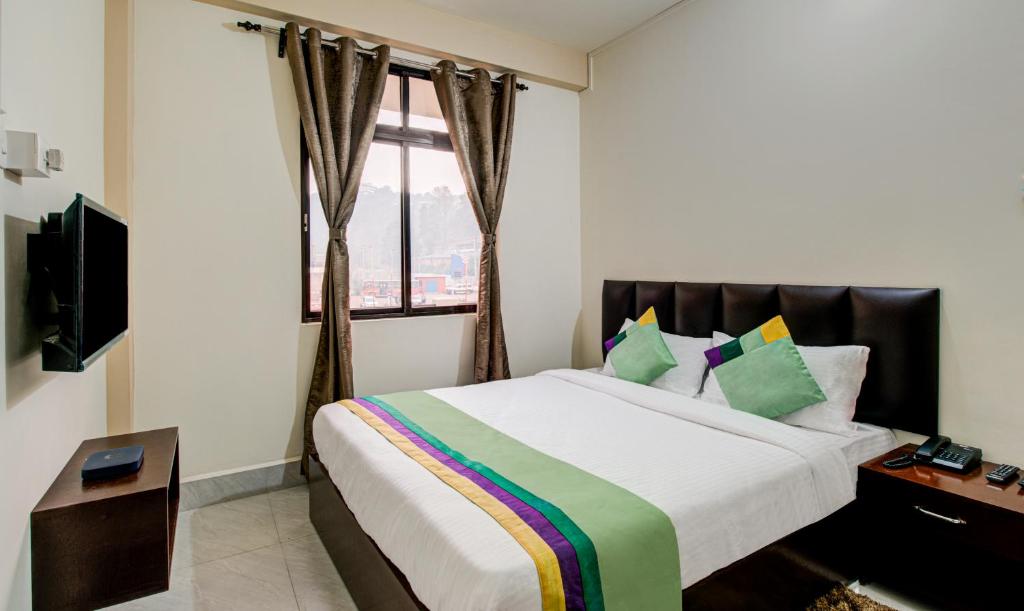 a bedroom with a large bed and a window at Treebo Trend Staying Center in Shillong