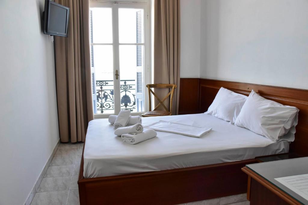 une chambre d&#39;hôtel avec un lit et une fenêtre dans l&#39;établissement Leonidas Hotel, à Gythio