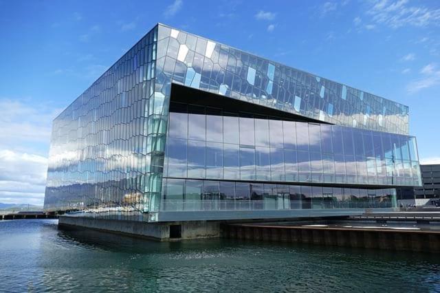 a glass building next to a body of water at 2x Bedroom Luxury Apartment with amazing views! in Reykjavík