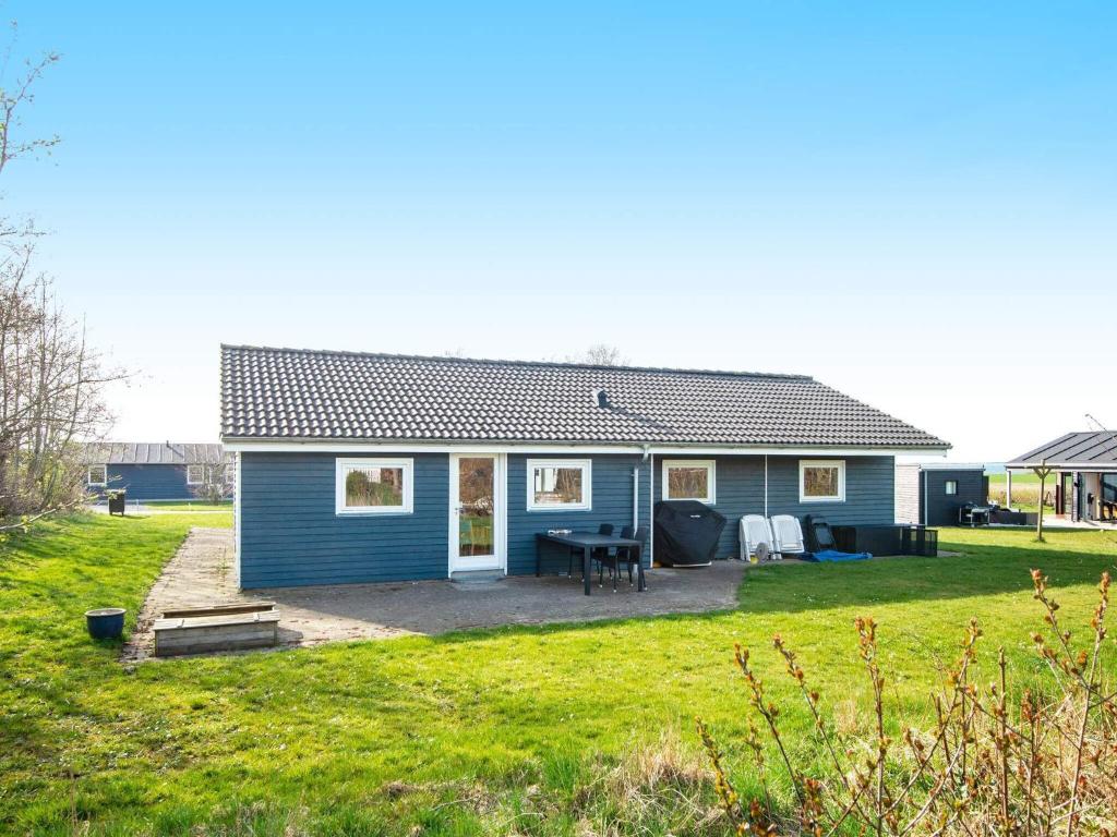 ein blaues Haus mit einem Tisch im Hof in der Unterkunft 12 person holiday home in Vinderup in Vinderup