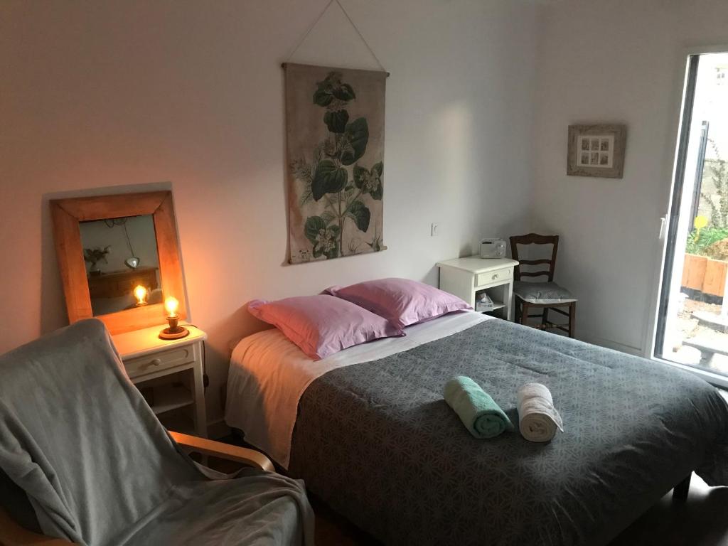 1 dormitorio con 1 cama con silla y espejo en Cocon de douceur à deux pas de la gare, en Montauban-de-Bretagne