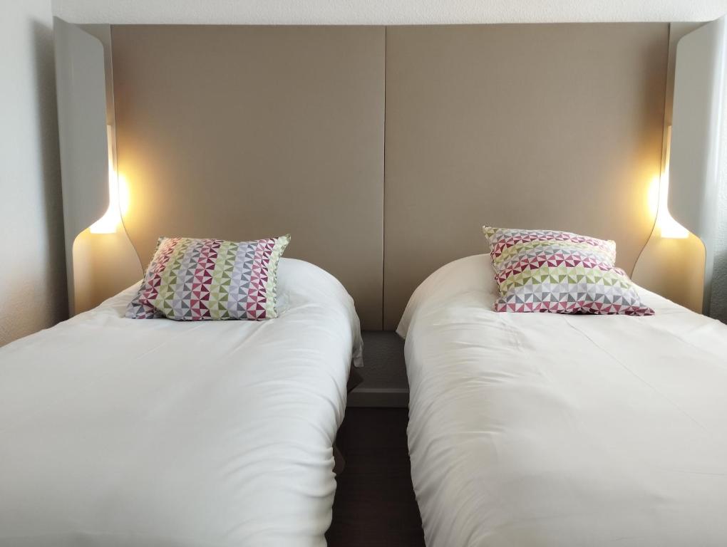 2 camas en una habitación con 2 almohadas en Noemys ARLES, en Arles