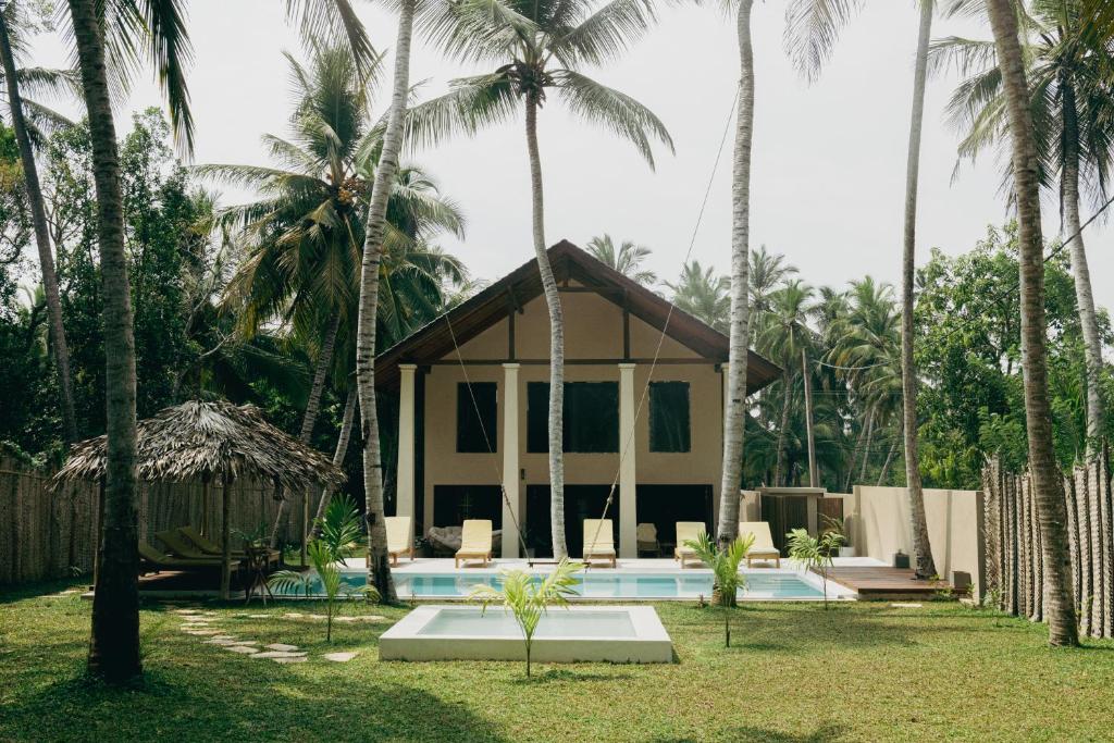 um resort com piscina e palmeiras em Ocean Divine em Kalametiya