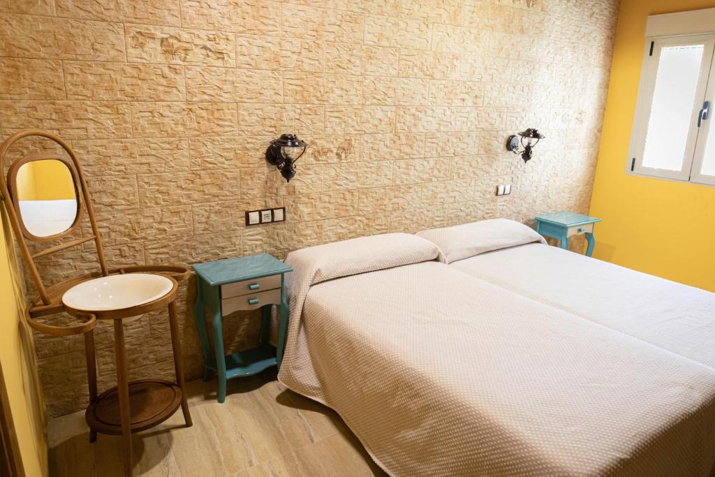 Hotel Un lugar en la Vecilla في Dueñas: غرفة نوم بسرير ومغسلة ومرآة