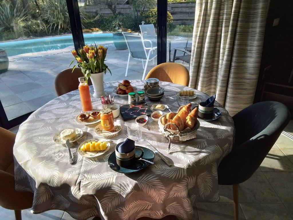una mesa con un desayuno de pan y fruta en ella en Laie des Landes, en Soucelles