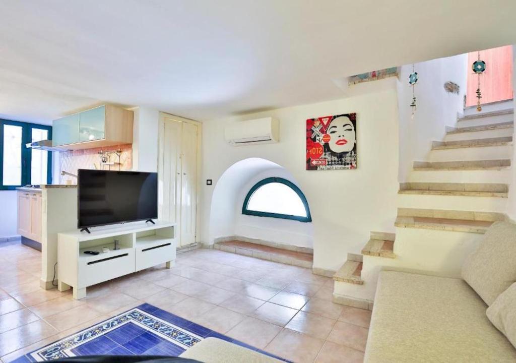 uma sala de estar com uma televisão e uma escada em La Tata home em Salerno