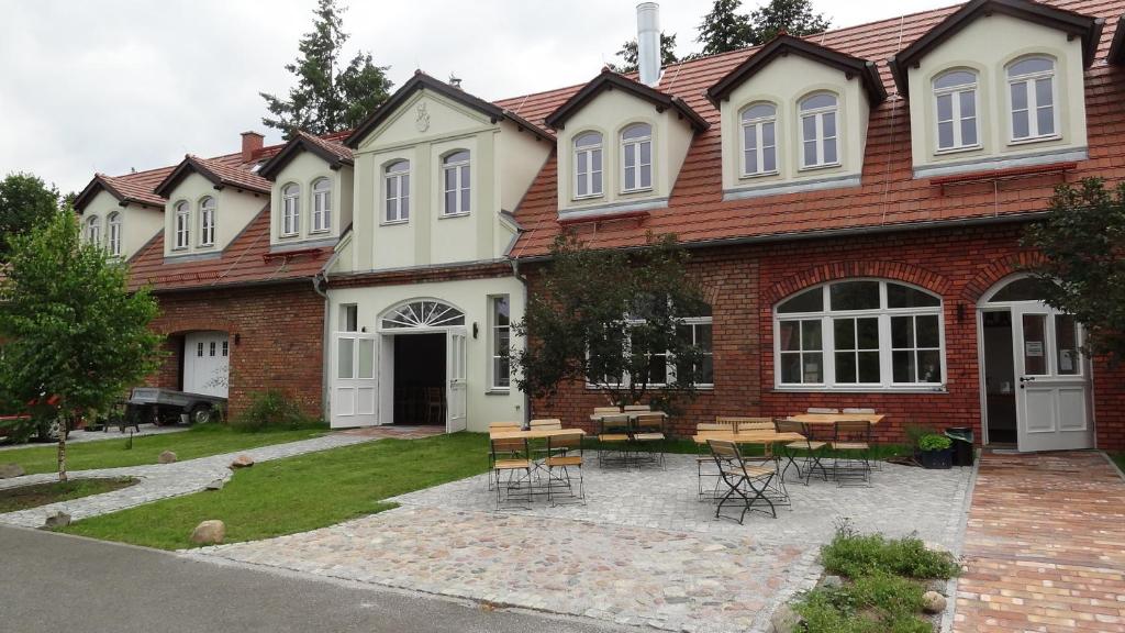 a house with a table and chairs in front of it at Pension Kchischowka in Vetschau