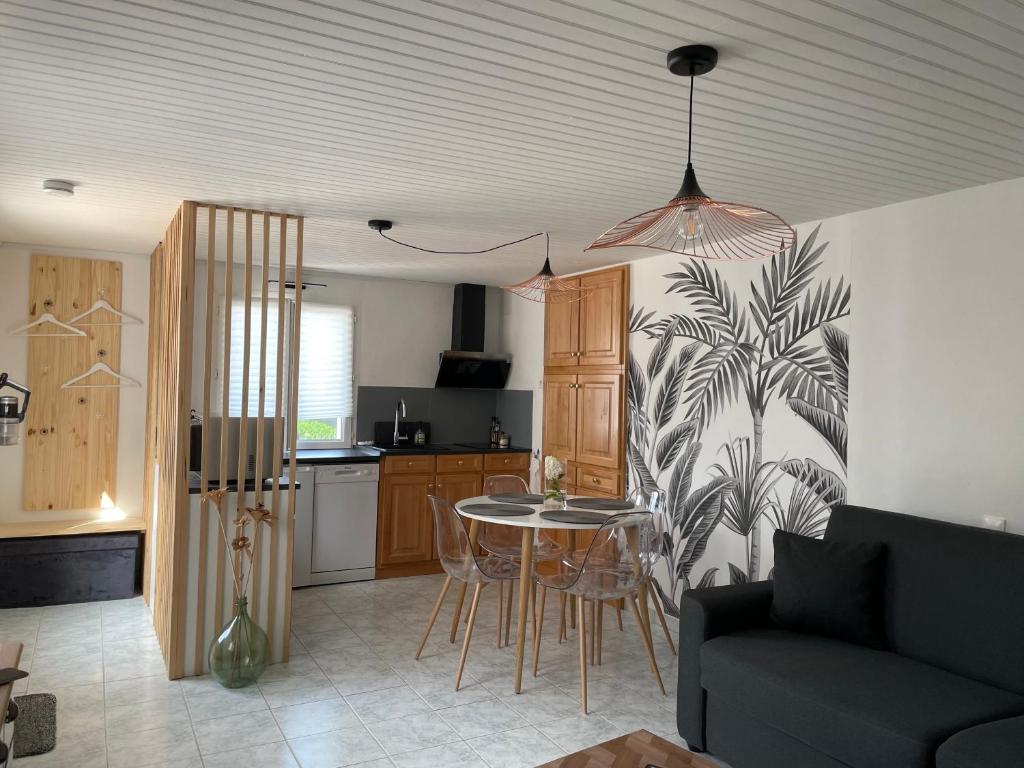 a kitchen and a living room with a table and chairs at Studio cosy in Mende