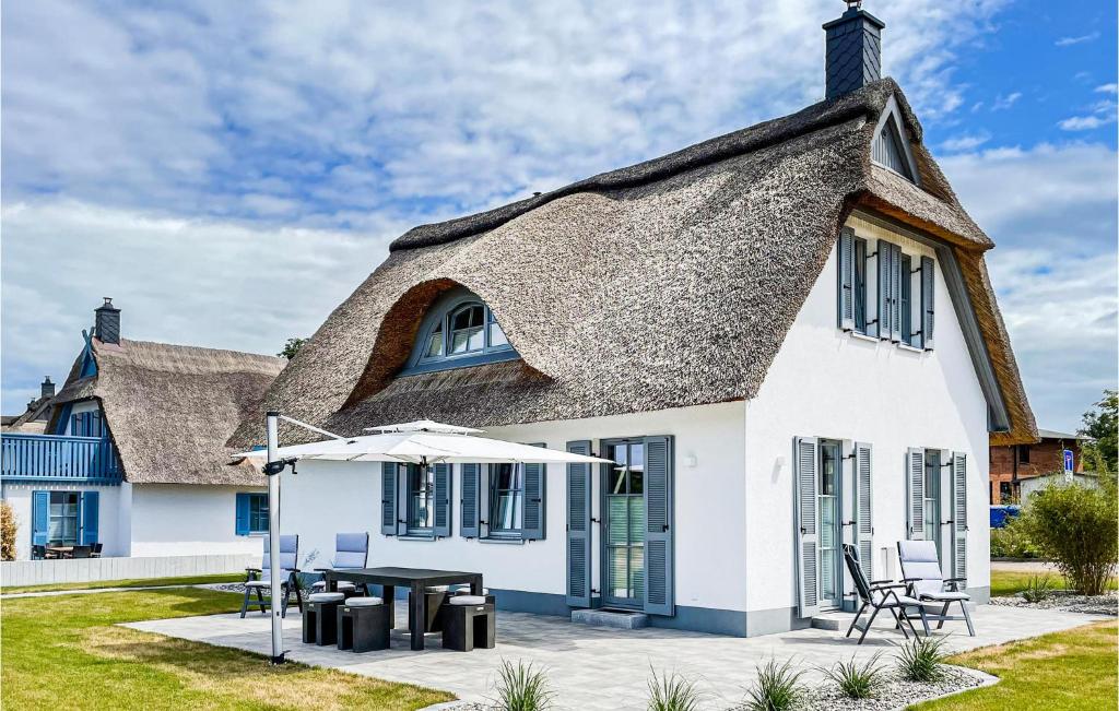 Casa con techo de paja, mesa y sombrilla en 2 Bedroom Lovely Home In Boiensdorf, en Güstow