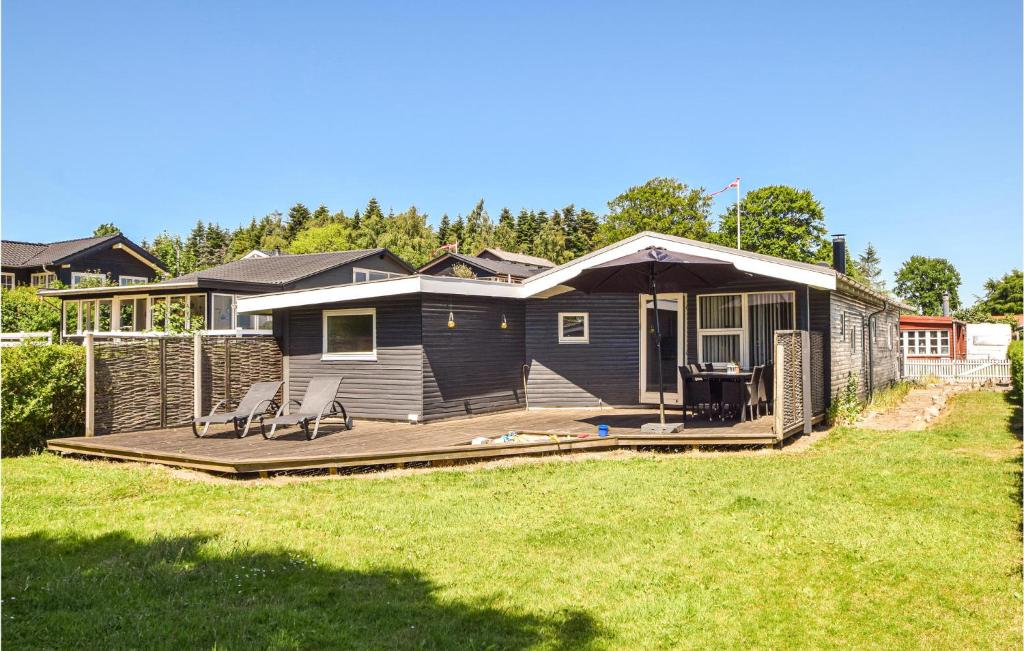 a house with a deck with two chairs on it at Beautiful Home In Bjert With Wifi in Sønder Bjert