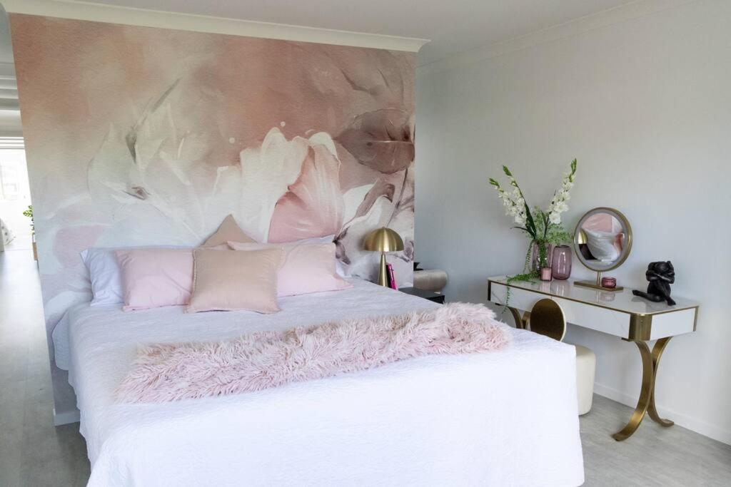 sypialnia z białym łóżkiem i obrazem na ścianie w obiekcie Serenity Cove luxe retreat w mieście Maroochydore