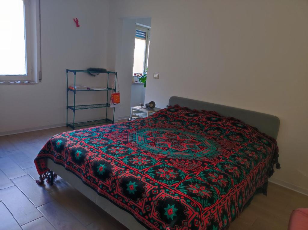 una camera da letto con un letto con una coperta rossa sopra di L'appartamentino a Reggio di Calabria