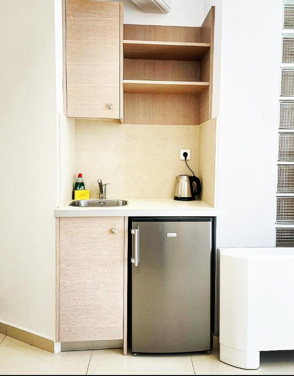 a small kitchen with a refrigerator and a sink at Pal Beach in Palaiochora