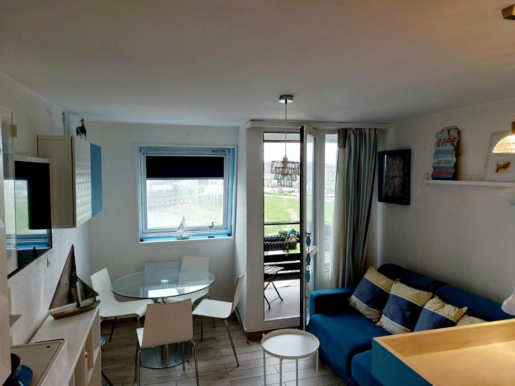 a living room with a blue couch and a table at Appartement Marina magnifique vue in Deauville