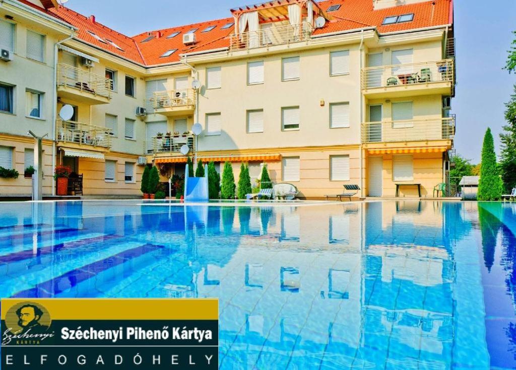 a large swimming pool in front of a building at Oázis Wellness Apartman2 in Hajdúszoboszló