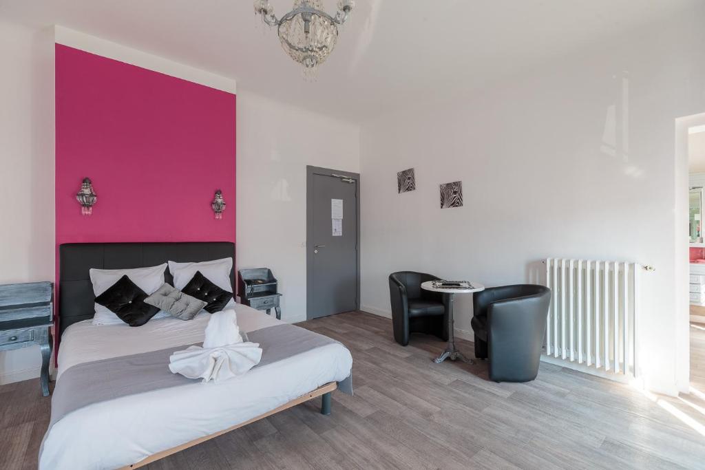 - une chambre avec un lit et un mur violet dans l'établissement Crystal Hotel, à Royan