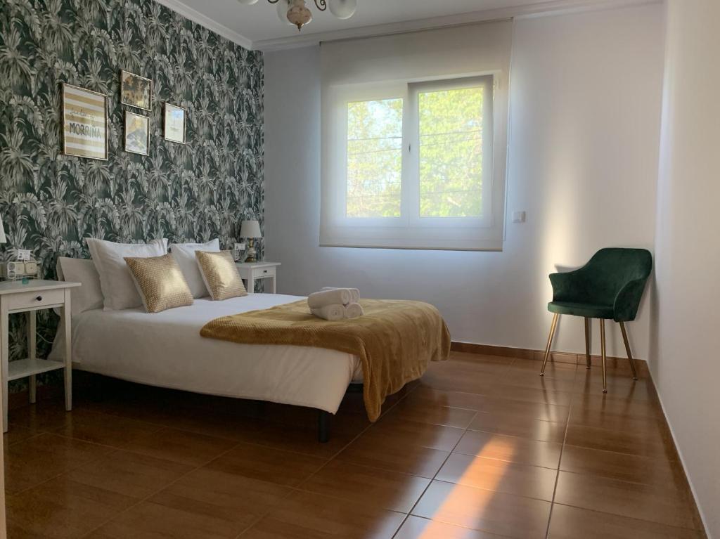 a bedroom with a bed and a window and a chair at Falda do Pedroso in Santiago de Compostela