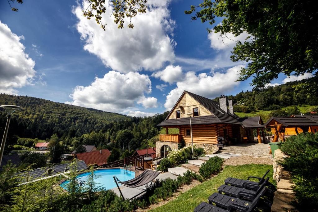 una casa con piscina frente a una casa en Kocierska Chata en Kocierz Rychwałdzki