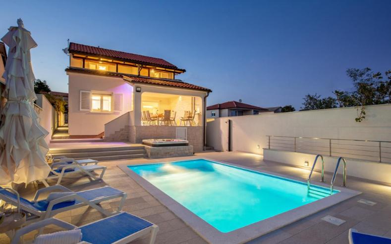 a swimming pool in front of a house at Villa Sunrise in Lopar