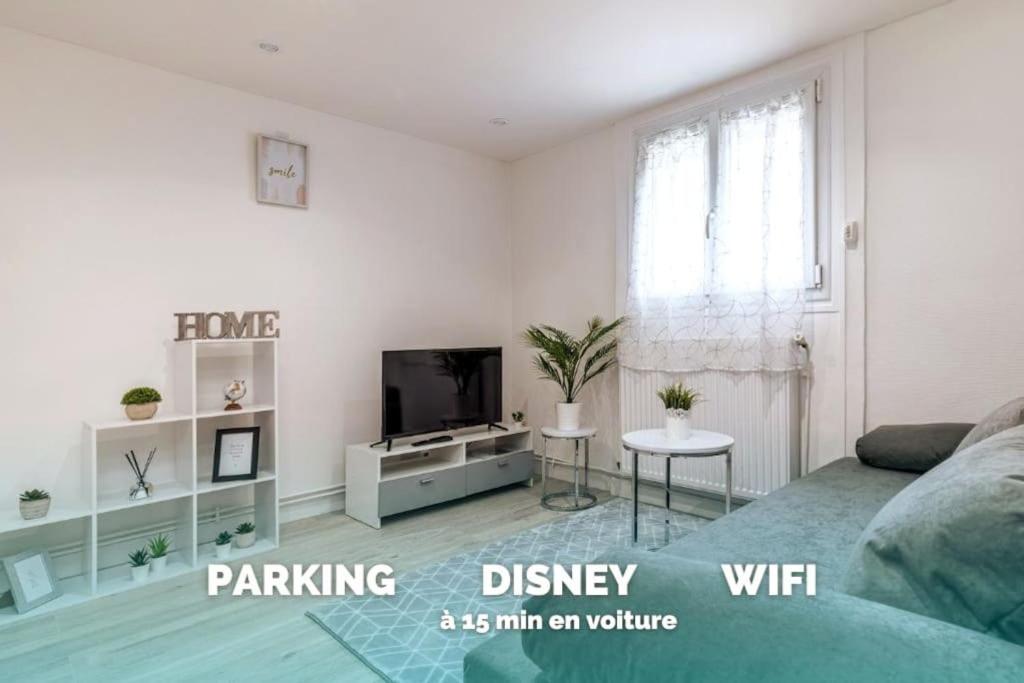 un salon avec un canapé et une télévision dans l'établissement Loc Enjoy by Disneyland, à Jablines