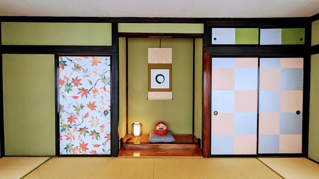 une chambre avec deux portes en verre et un animal farci dans l'établissement 富士吉田たまきや, à Fujiyoshida