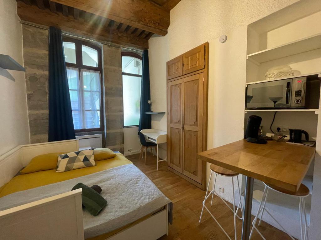 um pequeno quarto com uma cama e uma secretária. em Studio vieille ville em Besançon
