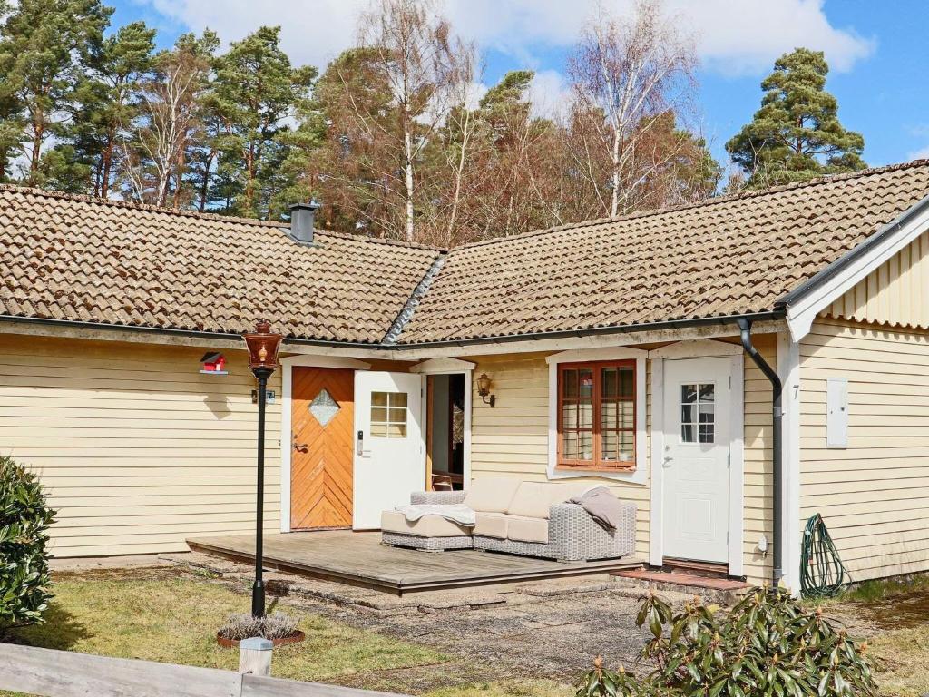 een klein wit huis met een veranda en een terras bij Holiday home BÅSTAD in Båstad
