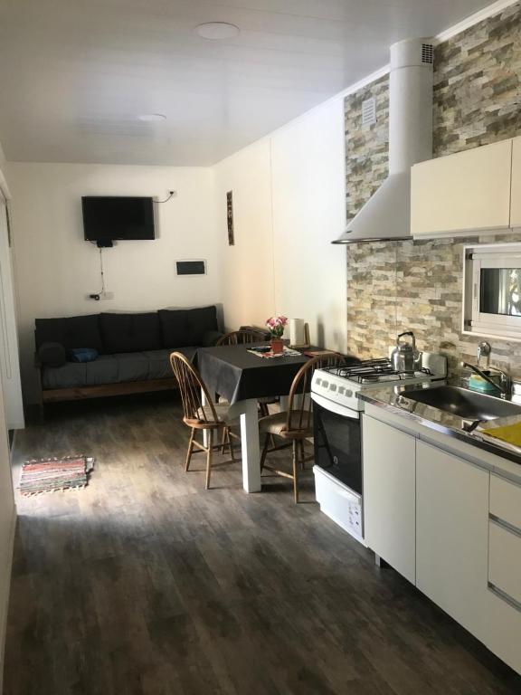 eine Küche und ein Wohnzimmer mit einem Tisch und einer Couch in der Unterkunft Los Amancay del Otto ventana in San Carlos de Bariloche