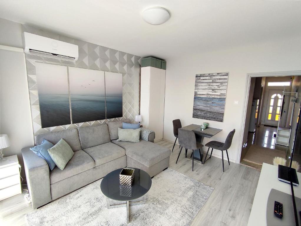 ein Wohnzimmer mit einem Sofa und einem Tisch in der Unterkunft LAKE APARTMAN in Balatonfüred