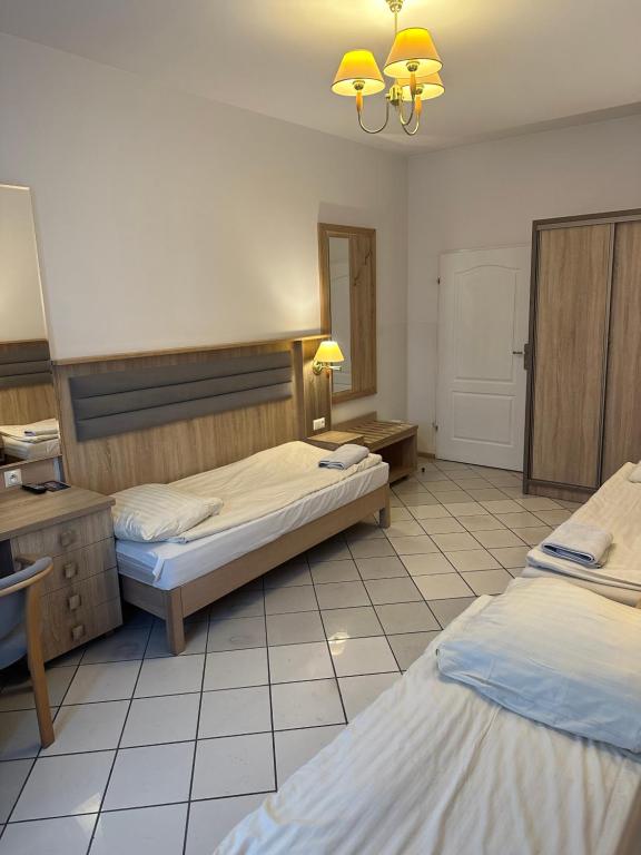 pokój hotelowy z dwoma łóżkami i lustrem w obiekcie Lotos w mieście Rawicz