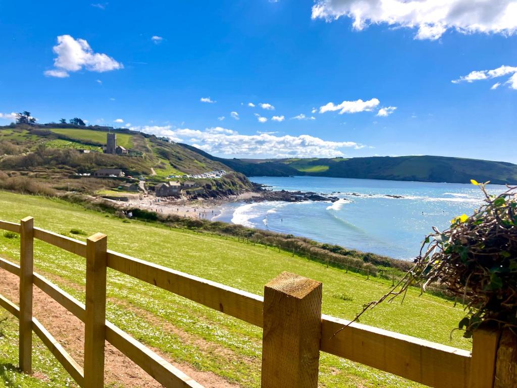 a wooden fence with a view of the ocean at Churchwood Valley in Plymouth