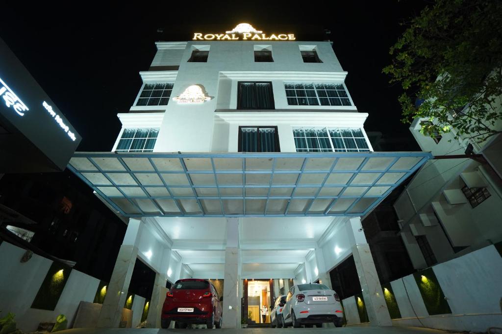 a white building with cars parked in front of it at Hotel Royal Palace in Guwahati
