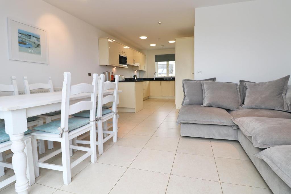 a living room with a table and a couch at BY THE BEACH, The Quies, Beach House in St Merryn
