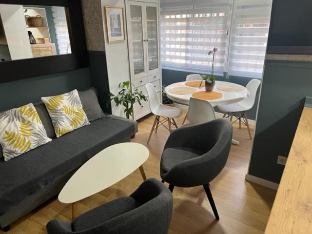 sala de estar con sofá, sillas y mesa en Apartamento Vallecas Plaza, en Madrid