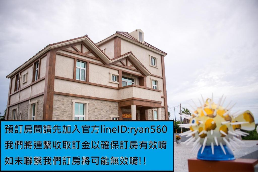 a building with a sign in front of it at Ryan's Guesthouse in Xiyu