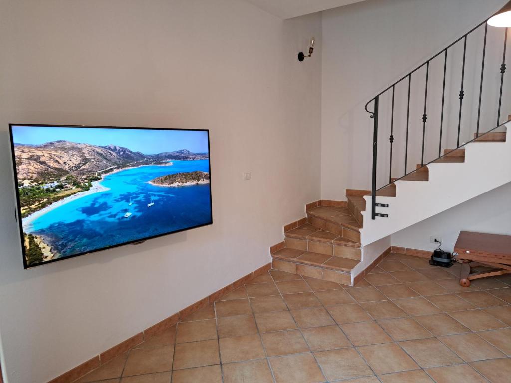 a living room with a flat screen tv on the wall at Santa Teresa Gallura Green House in Santa Teresa Gallura