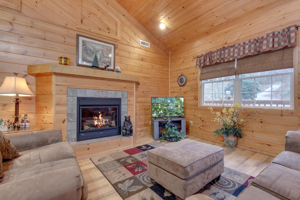 a living room with a fireplace in a log cabin at A Garden Blessing, 1 Bedroom, Hot Tub, Fireplace, Grill, WiFi, Sleeps 4 in Gatlinburg
