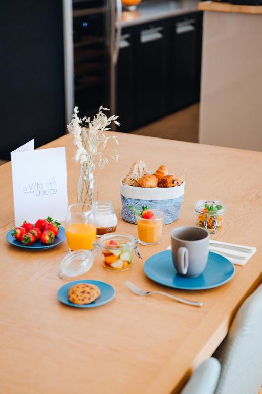 a table with plates of food and a bowl of fruit at Hôtel La Villa Douce in Rayol-Canadel-sur-Mer