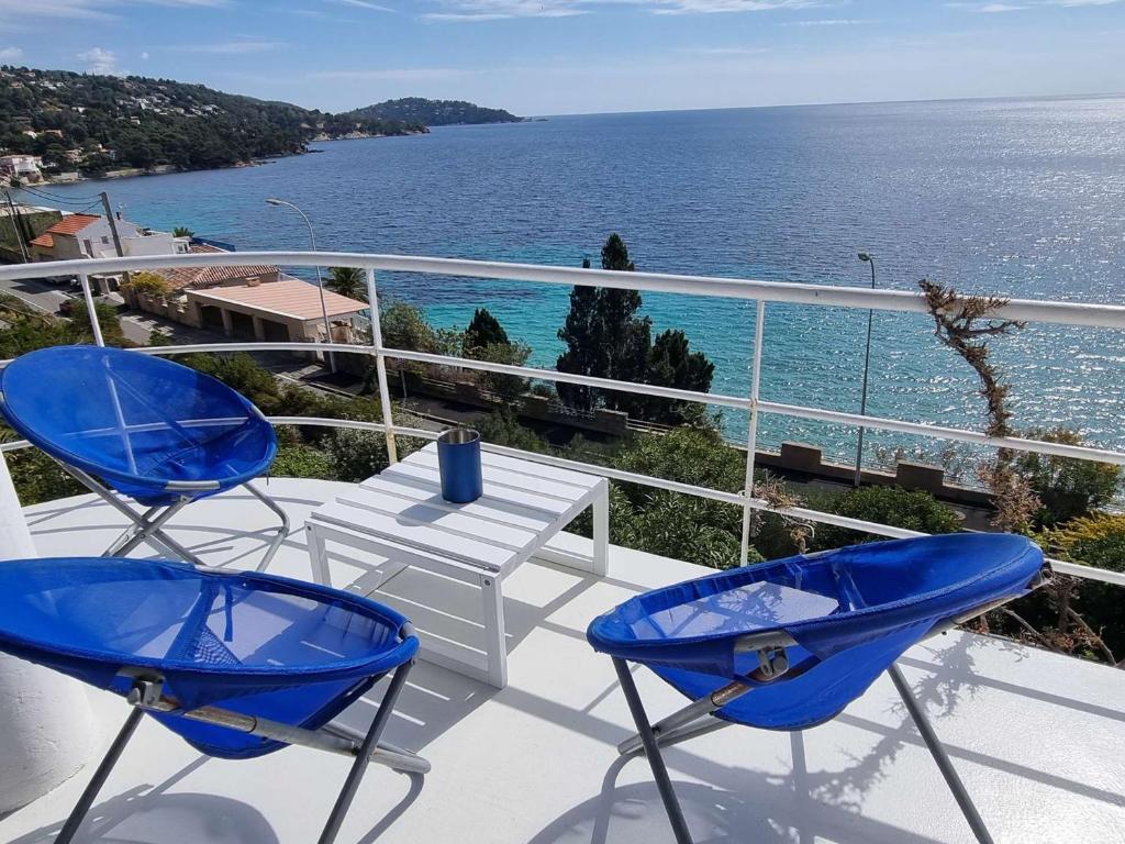 - un balcon avec deux chaises et une table donnant sur l'océan dans l'établissement Villa au Lavandou avec terrasse, climatisation et option Wi-Fi - FR-1-308-174, au Lavandou