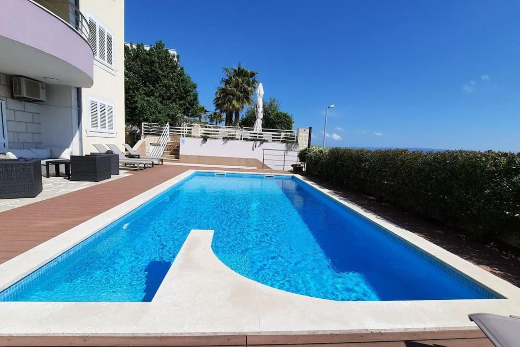 a swimming pool in front of a house at SUN apartment with SEA VIEW and shared POOL in Split
