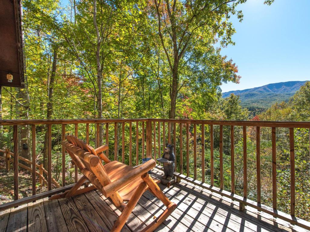 a wooden deck with a wooden chair on a balcony at Rustic Charm in Gatlinburg