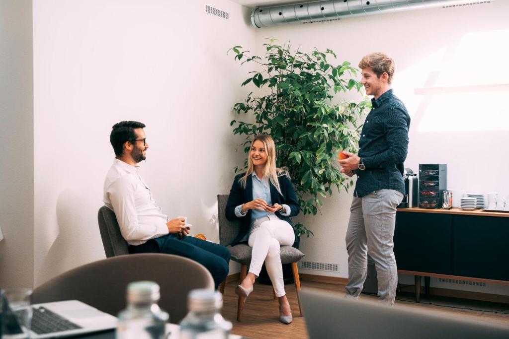 a group of three people in an office talking at Hotel Wettstein in Basel