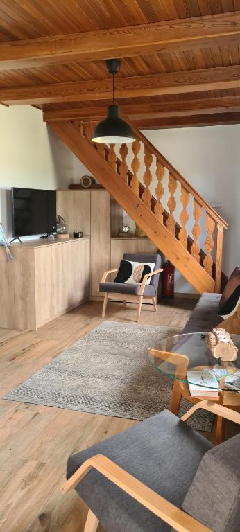 a living room with a couch and a staircase at Chata Pinie in Ivančice