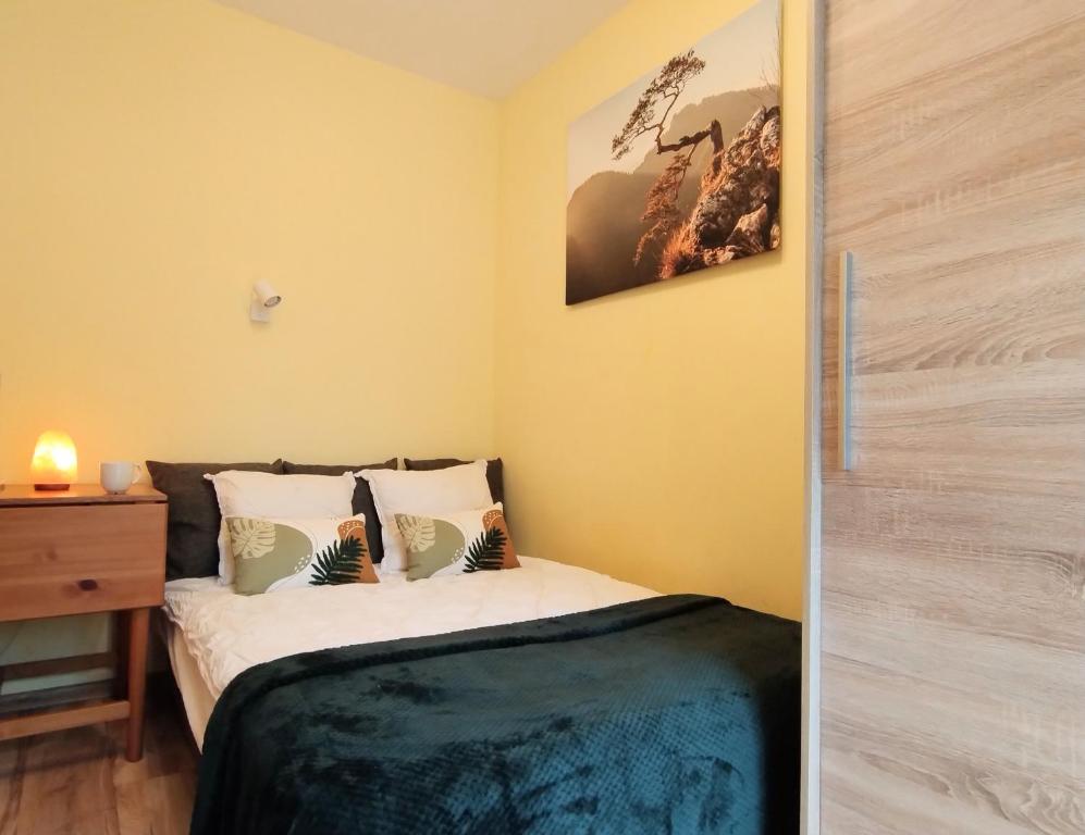 a small bedroom with a bed and a dresser at Yellow Apartment in Wieliczka