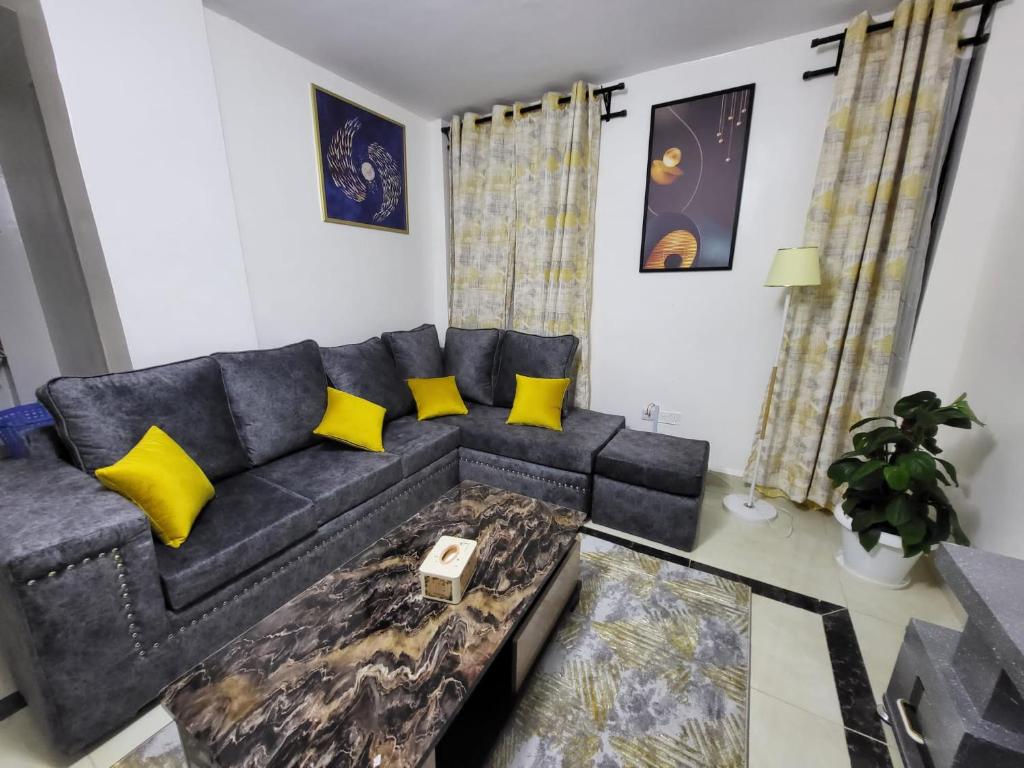 內羅畢的住宿－Inviting 1 Bed Apartment in Nairobi，客厅配有黑色沙发和黄色枕头