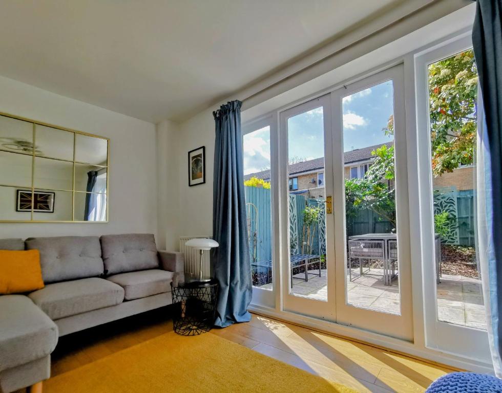 a living room with a couch and sliding glass doors at Beautiful 4 bedroom terrace house in Kings in London