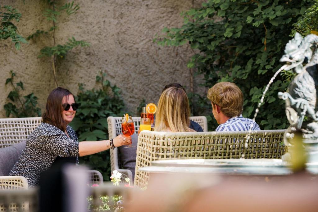 a group of people sitting at a table with drinks at Hotel Wettstein in Basel