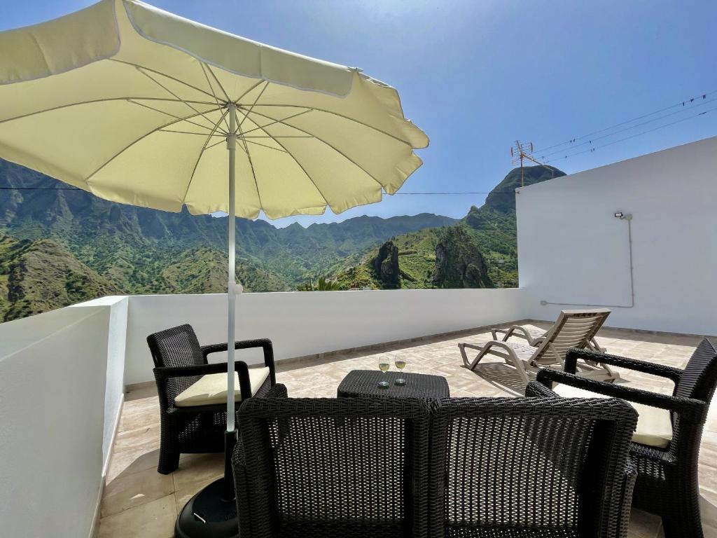 stół i krzesła z parasolem na balkonie w obiekcie Ca Yaya - Big House with Terraces - Rooftop & Views w mieście Hermigua